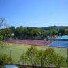 Vista di un campo sportivo all'aperto con recinzione, accanto a una piscina.