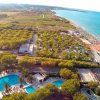 Vista aerea di un campeggio con piscine e spiaggia.