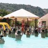 Persone in piscina partecipano a un'attività guidata da un'istruttrice.
