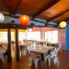Ristorante con tavoli e sedie bianche, lampade colorate.