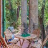 Balcone con sedie in legno e vista sul bosco.