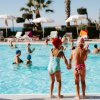 Due bambini con cuffie in piedi a bordo piscina.