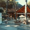 Ristorante all'aperto con tavoli sotto gli alberi.