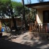 Veranda in legno con asciugamani, circondata da alberi.