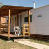 Veranda in legno di una casa mobile con sedia bianca.