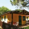 Casa gialla con veranda e piccola recinzione in legno.