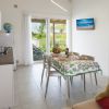 Cucina moderna con tavolo apparecchiato e accesso al giardino.