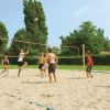 Sei persone giocano a beach volley.