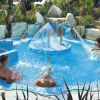 Persone si rilassano in una piscina con getti d'acqua.