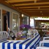Veranda coperta con tavolo e sedie bianche.