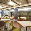 Sala caffetteria con sedie colorate.