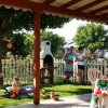 Giardino con tavolo apparecchiato e bambini che giocano.