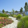 Un giardino curato con vialetti lastricati e casette bianche.
